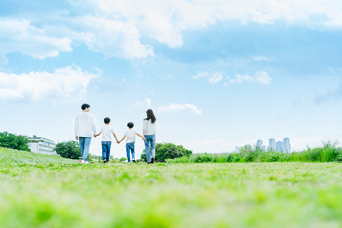 青空の下で手をつなぐ家族